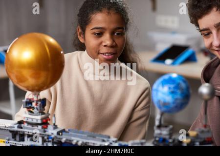 Portrait de fille adolescente noire construisant des robots tout en appréciant l'ingénierie et la robotique classe à l'école, l'espace de copie Banque D'Images