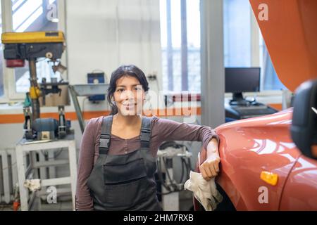 Portrait de femme mécanicien regardant l'appareil photo en voiture dans un atelier de réparation automobile, espace de copie Banque D'Images
