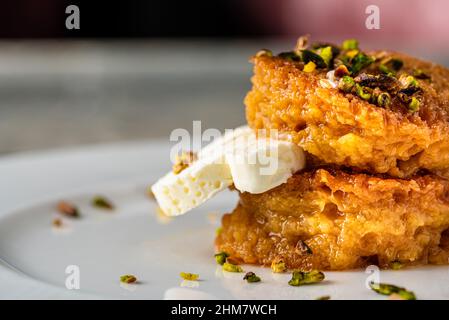 Un kadayif de pain ou un Kadayifi d'Ekmek accompagné de crème, un délicieux dessert turc servi dans un restaurant gastronomique Banque D'Images