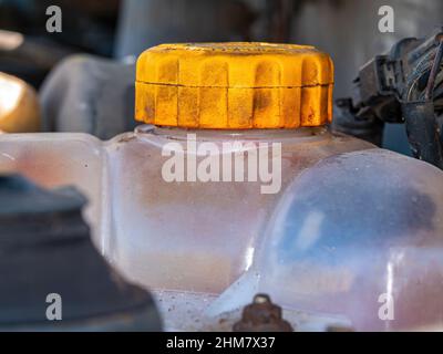 Réservoir en plastique avec un bouchon jaune pour l'antigel du circuit de refroidissement du moteur de voiture. Banque D'Images