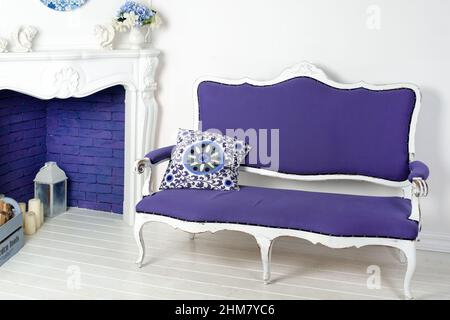 Séjour avec un canapé bleu clair très péri couleur 2022. Cheminée, bougies et fleurs, maison confortable dans des couleurs tendance Banque D'Images