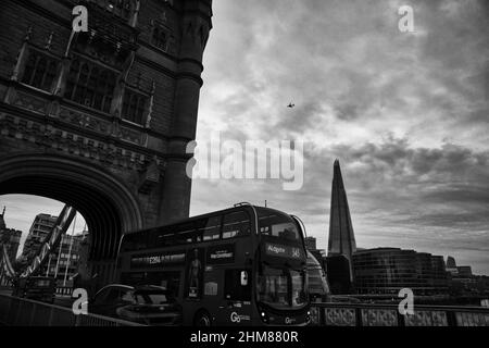 Sur Tower Bridge en regardant vers le shard comme un bus rouge passe Banque D'Images