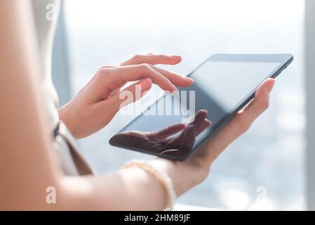 Photo en gros plan des mains de femmes travaillant avec l'ordinateur tablette. Femme à l'aide de réseau social, les sms et les blogs Banque D'Images