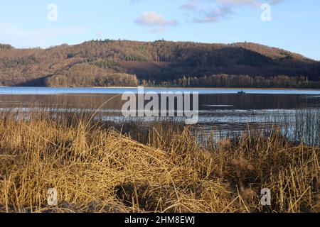 Maria Laach, Laacher See, Allemagne, février 2022, vue sur le lac juste avant le coucher du soleil dans la belle lumière du soleil et le temps avec ciel bleu Banque D'Images
