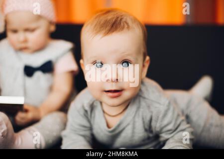 Bébé garçon aux yeux bleus, allongé et regardant l'appareil photo. Banque D'Images