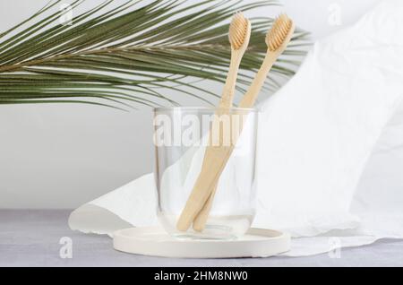 Deux brosses à dents en bois dans un bol en verre transparent. Soins buccaux. Banque D'Images