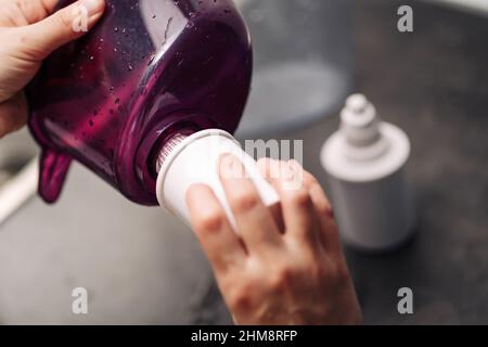 Femme remplaçant le filtre dans un pichet à eau. Une main femelle retire une ancienne cartouche de purification de l'eau du robinet d'une verseuse. Le processus de remplacement d'un ancien wat Banque D'Images