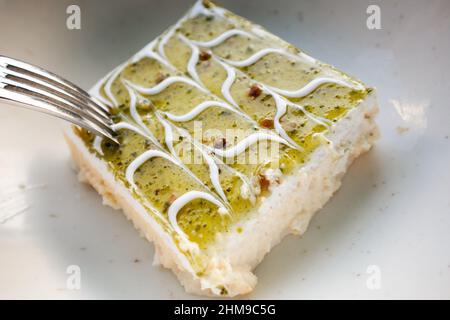 Portion de gâteau du restaurant iranien servie sur une assiette blanche. Banque D'Images