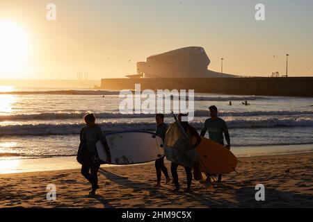 Un groupe de surfeurs transportant leurs planches de surf marche le long de la plage de Matosinhos.les gens surfent sur la plage de Matosinhos même pendant la pandémie de Covid-19. Banque D'Images