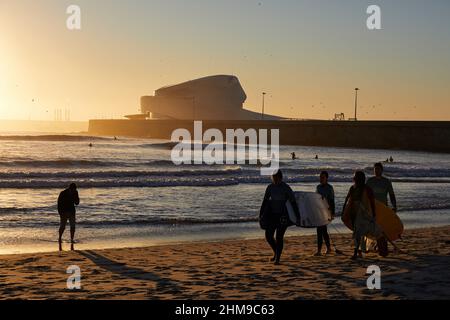 Un groupe de surfeurs transportant leurs planches de surf marche le long de la plage de Matosinhos.les gens surfent sur la plage de Matosinhos même pendant la pandémie de Covid-19. Banque D'Images