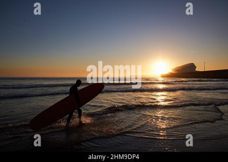 7 février 2022, Matosinhos, Porto, Portugal: La silhouette d'un surfeur transportant une planche de surf est à la plage de Matosinhos..les gens surfent à la plage de Matosinhos même pendant la pandémie de Covid-19. (Image de crédit : © Rita Franca/SOPA Images via ZUMA Press Wire) Banque D'Images