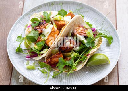 Tacos au saumon, chou rouge mariné, mayonnaise au wasabi et pousses de pois Banque D'Images