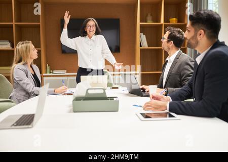 Femme d'affaires en tant que gestionnaire à l'atelier de formation et de coaching de motivation avec son équipe au bureau Banque D'Images