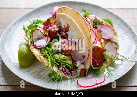 Tacos au saumon, chou rouge mariné, mayonnaise au wasabi et pousses de pois Banque D'Images