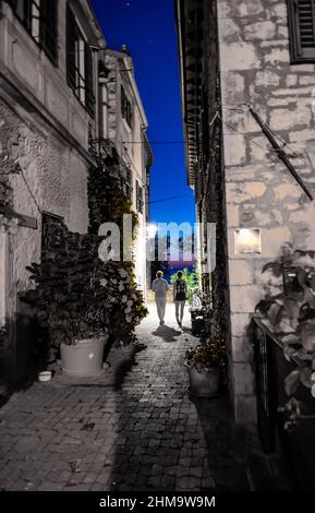 Deux femmes marchant à travers l'allée étroite abandonnée dans la nuit Banque D'Images
