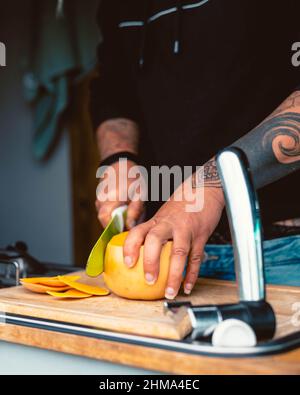 Récoltez une femelle anonyme en train de couper de la citrouille mûre fraîche sur une planche à découper en bois tout en préparant le déjeuner en caravane pendant le voyage en Cantabrie Banque D'Images
