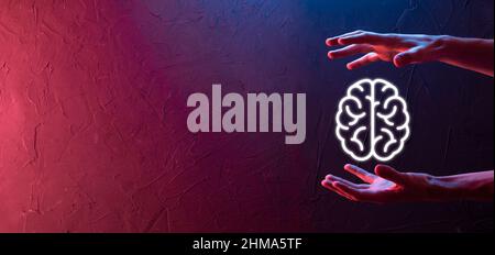 Main mâle tenant l'icône du cerveau sur fond rouge néon, bleu. Intelligence artificielle apprentissage machine Business Internet Technology concept.Banner avec co Banque D'Images