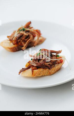 Bruschetta sur une plaque gros plan sur blanc. Banque D'Images