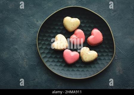 Gâteaux de macarons en forme de coeur. Petits gâteaux français pour la Saint-Valentin. Macarons français doux et colorés. Banque D'Images