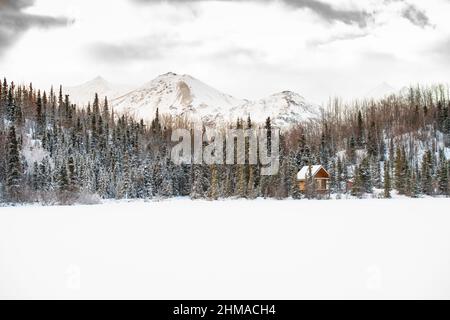 Petite cabine sur le côté d'un lac gelé en Alaska Banque D'Images