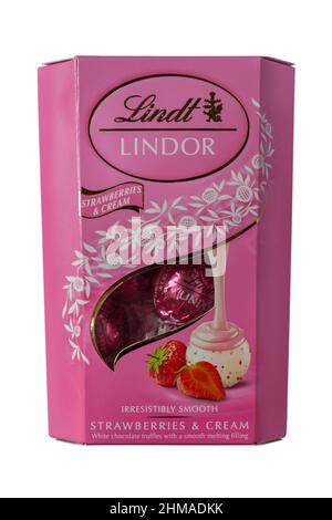 Boîte de fraises Lindor et de crème délicieusement douces truffes au chocolat blanc avec une garniture douce et fondue isolée sur fond blanc Banque D'Images