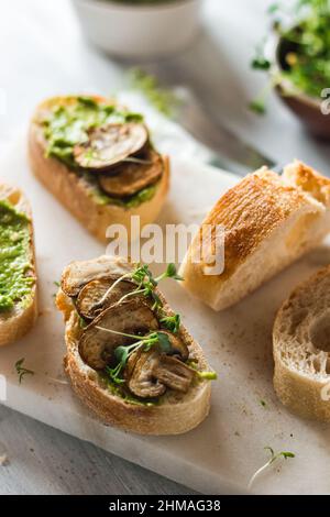 Baguette au guacamole, champignons et micro-vert sur plaque blanche. Idées de brunch. Source de protéines végétaliennes. Alimentation saine. Alimentation propre. Banque D'Images