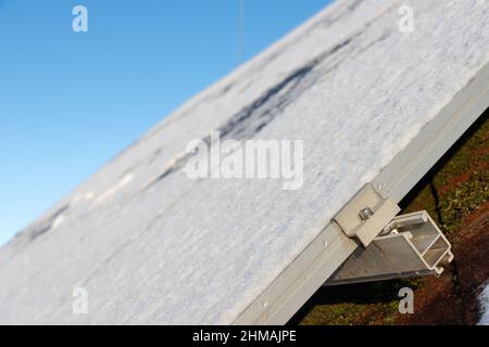 Panneaux solaires enneigés sur le toit d'une maison. Banque D'Images