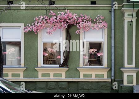 Une fausse fleur rose parsemée de fenêtres. Une merveilleuse combinaison de vert et de rose dans l'architecture de la ville. Banque D'Images