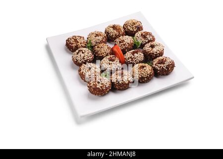 Photo studio d'un falafel de plat arabe sur une plaque blanche carrée isolée sur fond blanc Banque D'Images