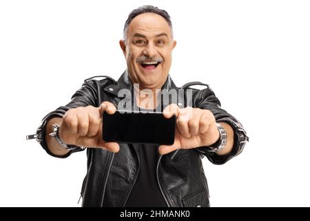 Homme mûr souriant dans une veste en cuir prenant une photo avec un appareil photo de smartphone isolé sur fond blanc Banque D'Images