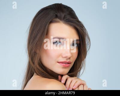 Peau naturellement douce. Studio portrait d'une belle jeune femme posant sur un fond bleu. Banque D'Images