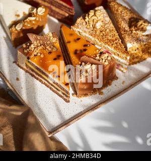 Assortiment de morceaux de gâteau sur l'assiette, espace de copie. Plusieurs tranches de délicieux desserts, concept de menu de restaurant, vue de dessus Banque D'Images