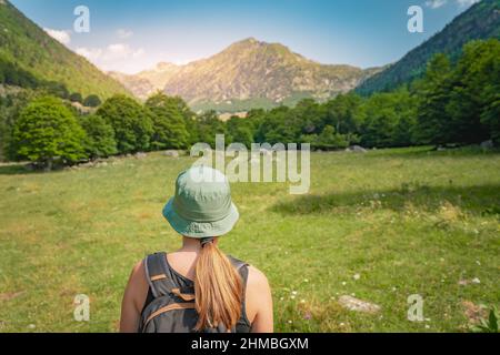 Jeune femme avec Un sac à dos randonnée dans une belle vallée entre les montagnes pendant le coucher du soleil. Concept de destination de voyage Discovery Banque D'Images
