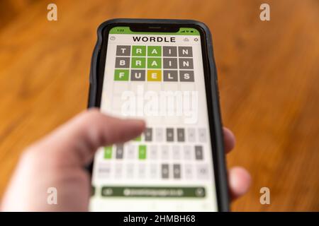 Brandon, MS - 8 février 2022: Mains jouant Wordle jeu au téléphone. Banque D'Images