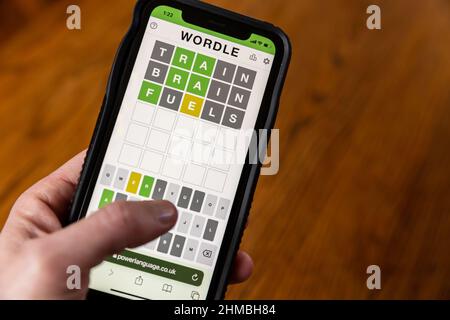 Brandon, MS - 8 février 2022: Mains jouant Wordle jeu au téléphone. Banque D'Images