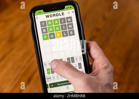 Brandon, MS - 8 février 2022: Mains jouant Wordle jeu au téléphone. Banque D'Images