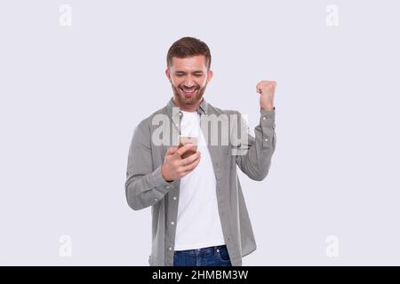 Homme excité gagnant. Homme tenant le téléphone. Gagnant. Man a gagné Casino en ligne, Loterie Banque D'Images