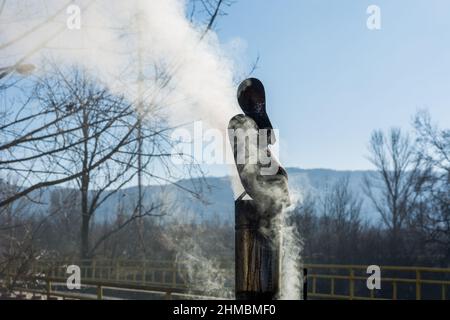 Fumée sortant d'une cheminée en étain sur un toit lors d'une journée d'hiver ensoleillée. Gros plan, mise au point sélective Banque D'Images