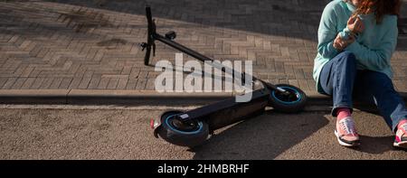 Une femme de race blanche est tombée d'un scooter électrique et a blessé son bras.Souffrant de douleur. Banque D'Images