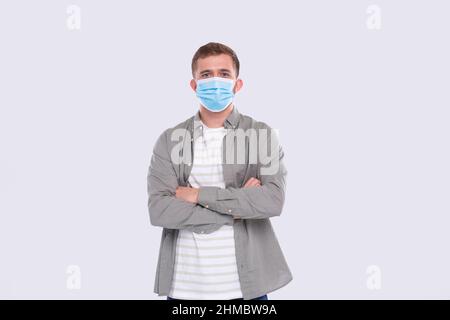 Homme portant des mains de masque médical croisé isolé. Chemise homme en vert avec masque médical. Santé, virus, concept médical Banque D'Images