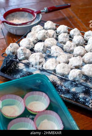 Un biscuit préféré, appelé boule de neige, biscuit de mariage mexicain, biscuit de mariage russe ou sandies de noix de pécan, est dépoussiéré avec une couche de sucre en poudre. Banque D'Images