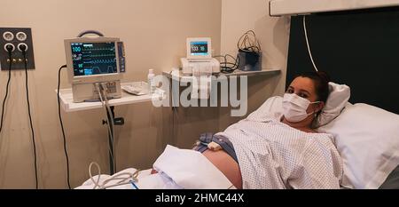 jeune femme enceinte dilatant dans la salle d'accouchement, attendant de donner naissance à l'hôpital Banque D'Images