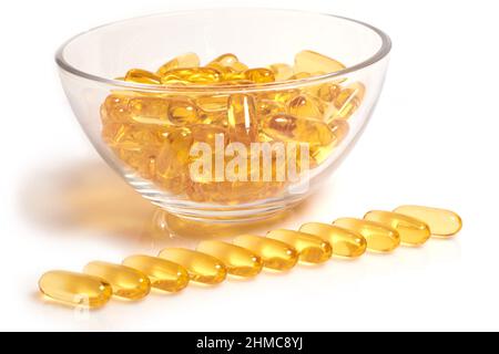 Capsules jaunes d'huile de poisson oméga-3 dans un bol en verre Banque D'Images