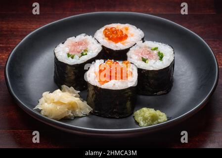 Décor de style japonais composé de petits pains à sushis avec caviar et poisson frais haché sur l'assiette, plats asiatiques et plats japonais traditionnels Banque D'Images