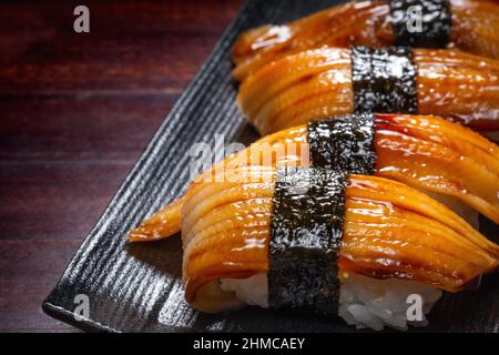 Sushi de style japonais avec poisson à anguille sur une assiette noire, cuisine asiatique, cuisine japonaise traditionnelle Banque D'Images