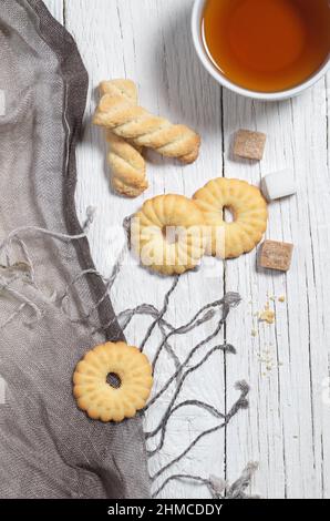 Vue en hauteur de divers biscuits sablés et une tasse de thé sur une table en bois blanc Banque D'Images