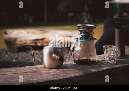 La cafetière est placée sur une chaise en bois dans le camping. Banque D'Images