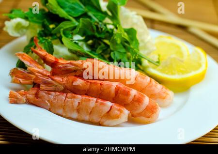 crevettes sur une assiette avec citron et salade Banque D'Images