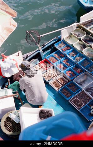 Pêcheur vendant des fruits de mer en bateau à Hong Kong Sai Kung, un village de pêcheurs traditionnel Banque D'Images