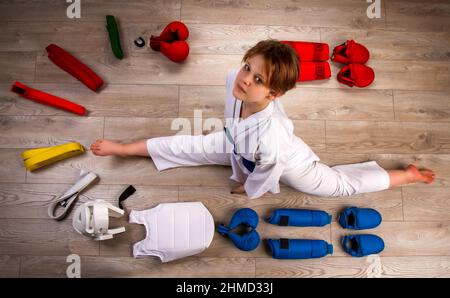 Image conceptuelle dans le style de la pose plate d'une petite carateka fille entourée par son équipement nécessaire pour la formation et la compétition Banque D'Images